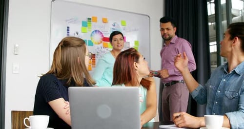 Team Collaboration Around Laptop in Modern Office