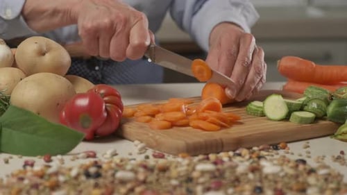 Zubereitung von Kochgemüse in der modernen Wohnküche. Karotte schneiden, vegane vegetarische Mahlzeit