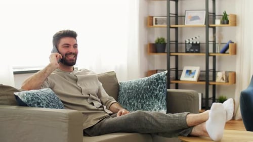 Man Chatting on Phone, Relaxing on Sofa