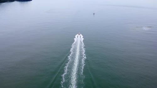 Aerial view from a drone of a white boat sailing on the blue sea Top view of a speedboat moving