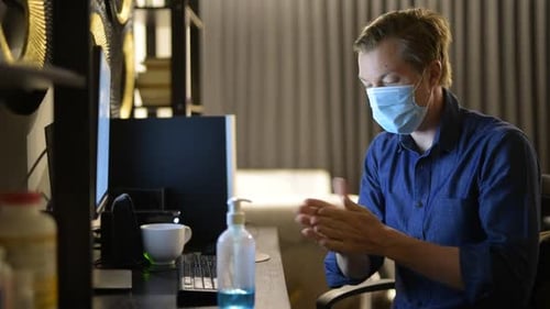 Man Wearing Mask Working on Computer at Home