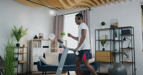 Adult Man Walks on Treadmill at Home