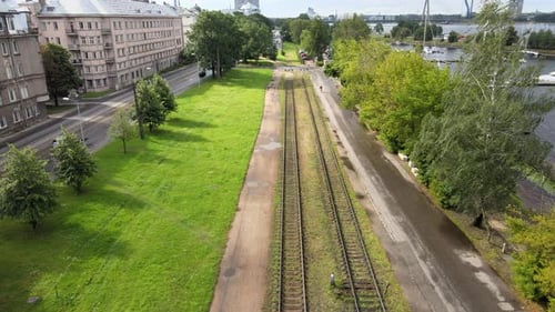 Aerial View of Cyclist Along Urban Train Tracks