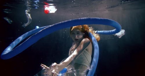 Woman Is Floating Inside Sea Water and Looking on Waste Around