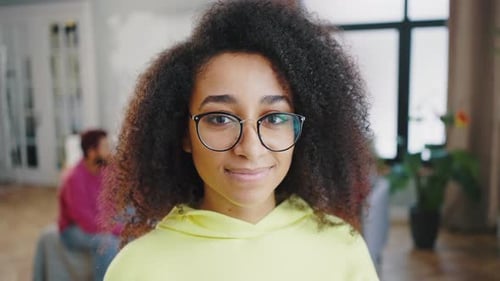 Close Up of Smiling Young African American Woman Girl Wearing Glasses in Yellow Sweatshirt