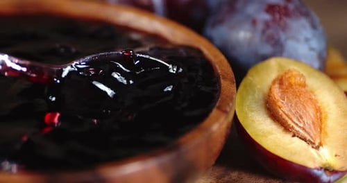À l'aide d'une cuillère, mélangez la confiture des prunes mûres