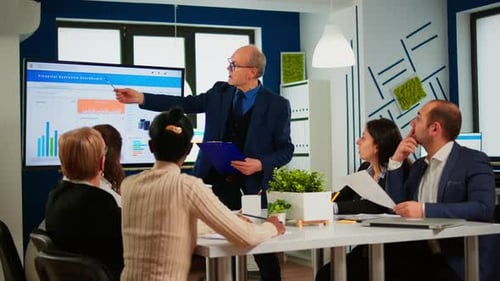 Adults Discussing Financial Data in Modern Office