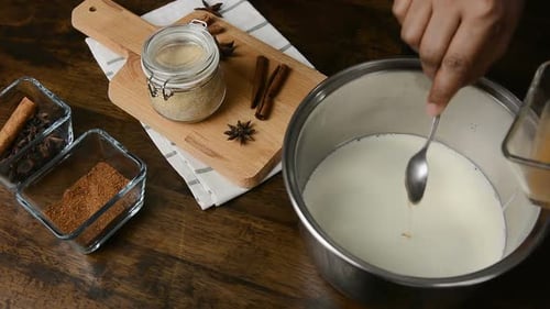 Die Zutat wird in den Milchtopf zum Kochen des Weihnachts-Eierlikörgetränks gegeben