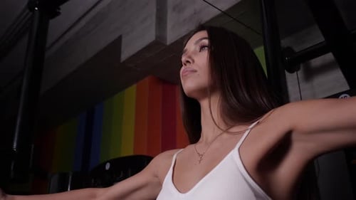 Young Woman Working Out in Gym on Machine