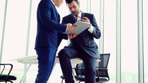 Two Business People Talk Project Strategy at Office