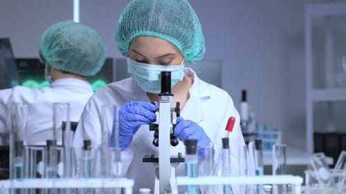 Woman Scientist Using Microscope in Lab