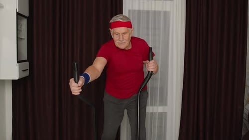 Senior Man Exercising on Elliptical Machine at Home