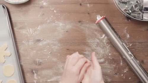 Hands cutting cookies from dough using cookie cutters