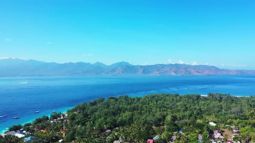 Idyllic tropical island with lush vegetation and a lot of resorts and holiday hotels surrounded by b