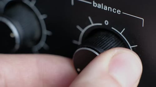 Finger Adjusting the Balance Knob on an Audio Mixer