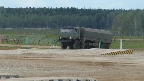 Military Truck Driving on Gravel Road
