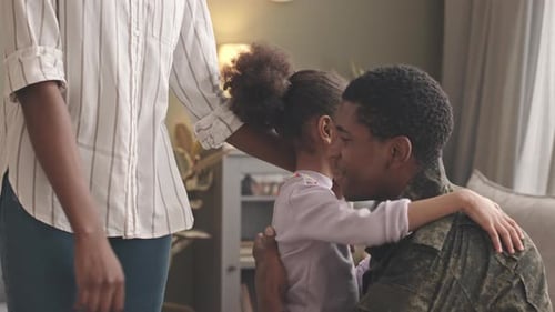 Military Dad Hugs Daughter and Wife at Home
