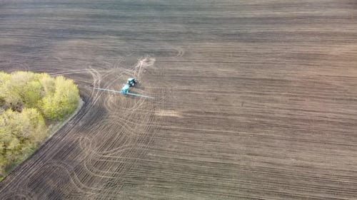 Aerial Traktor drehen und sprühen auf Landfeld