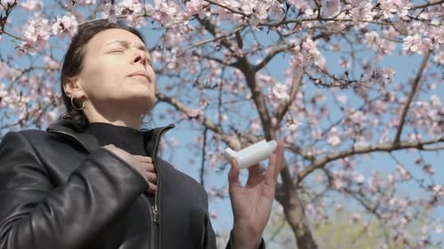 Woman Uses Inhaler for Asthma Outside in Spring
