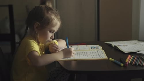 Young Girl Studying and Writing in Workbook