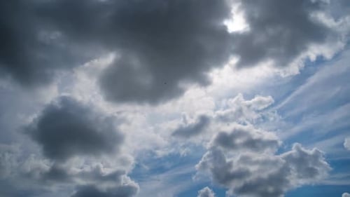 Les nuages se déplacent doucement dans le ciel bleu sur fond de soleil. Timelapse