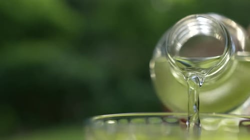 Clear Liquid Pouring into Glass Close Up
