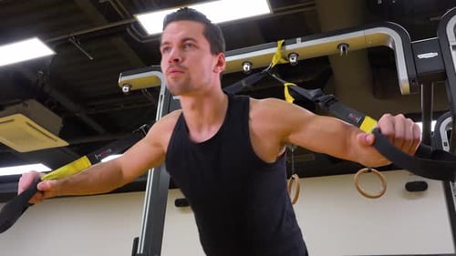 A Young Fit Man Does Inclined Push-ups in a Gym - Closeup From Below