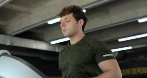 Active Attractive Strong Man in Sportswear Exercise By Running on Treadmill Machine in Sport Gym