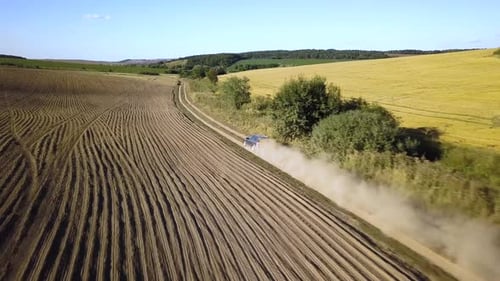 Top Down Aerial View of Fast Driving Car on Dirt Road Leaving Cloud of Dust Behind