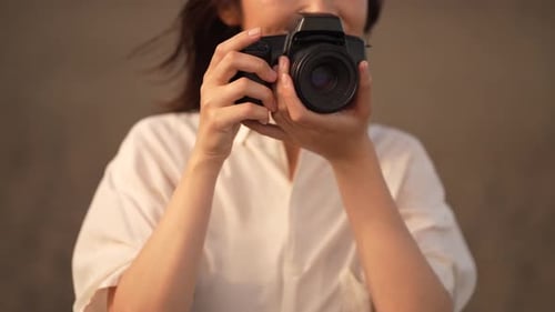 Woman Holds DSLR Camera and Smiles