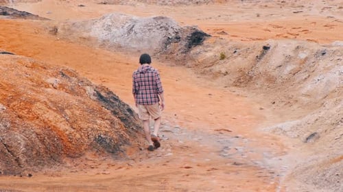 Young Adult Hiking Through Red Desert Landscape