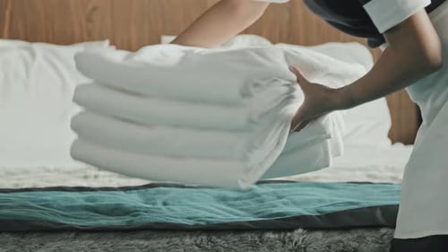 Ama de casa cambiando toallas en la habitación del hotel