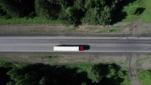 Summertime Aerial Imagery of White Truck Driving on Highway Road in Forest