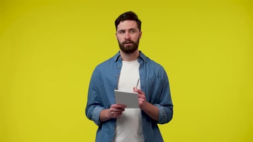 Portrait d'un Caucasien qui pense à quelque chose puis écrit quelque chose dans un carnet