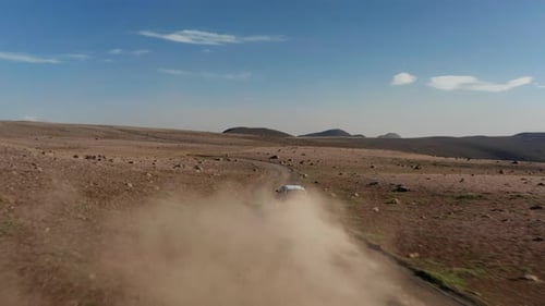 Car Driving Across Remote Desert Landscape