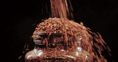 Instant Coffee Granules Being Poured into Jar