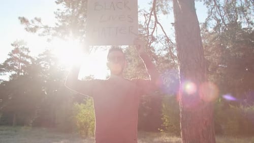 Adult Holding Black Lives Matter Sign in Forest