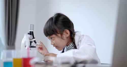 Young Girl Experimenting with Microscope and Test Tubes