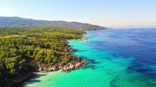 Aerial drone view of the Aegean sea rocky coast with blue transparent water