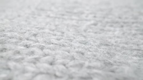 Extreme detail view of sheep wool cloth texture flowing in macro dolly shot.