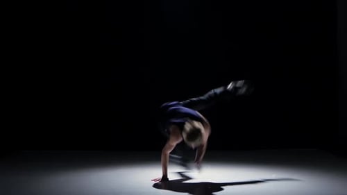 Breakdance Blonde Tänzerin im schwarzen Anzug beginnt Tanz auf Schwarz, Schatten