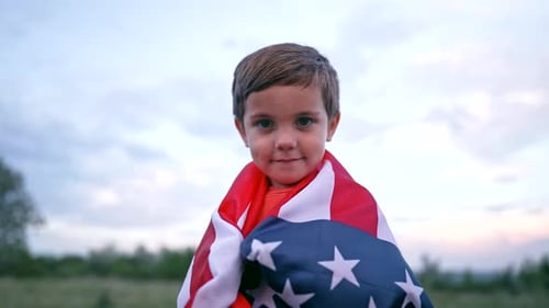 Child Wrapped in an American Flag in Field