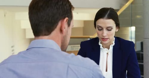 Businesswoman Explaining Details to Colleague in Office