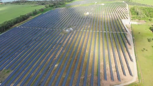 Luftaufnahme des Solarkraftwerks im grünen Feld in der Nähe des Flusses bei sonnigem Tag