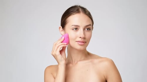 Woman Applies Makeup with Sponge