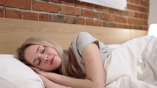Blonde Woman Sleeping Peacefully in Bed at Home