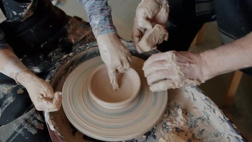 Close-up of Adult and Child's Hands Making Ceramic Bowl From Clay on Pottery Wheel
