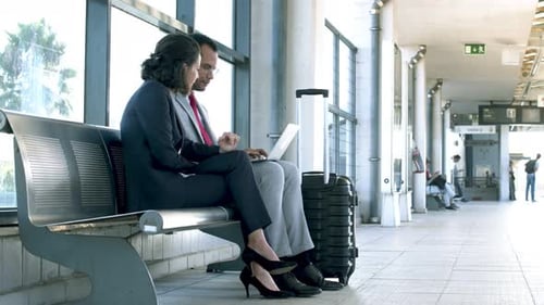 Business Colleagues Using Laptop at Railway Station