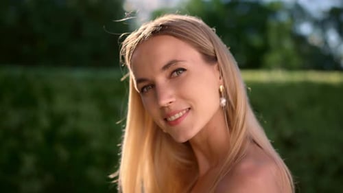 Smiling Woman with Blonde Hair and Pearl Earrings