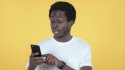 Wow, African Man in Awe Using Smartphone, Yellow Background